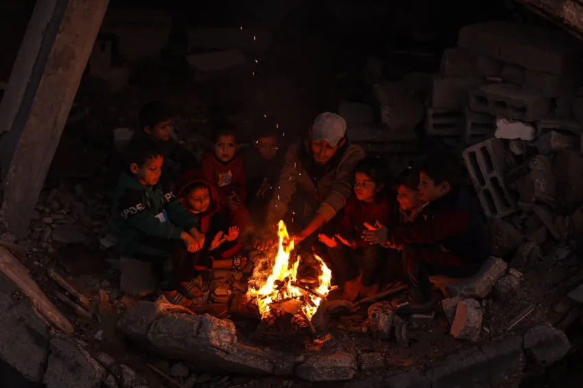 Crianças tentam se aquecer ao redor das fogueiras enquanto palestinos que vivem no bairro de Jabalia, no norte de Gaza, continuam suas vidas diárias em condições difíceis • Imagens de Khames Alrefi/Anadolu/Getty via CNN Newsource