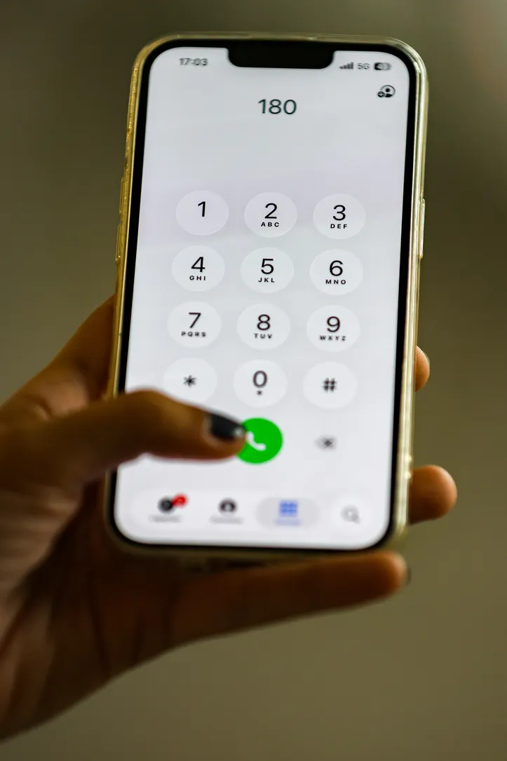 Smartphone com o número do disque denúncia de violência contra a mulher