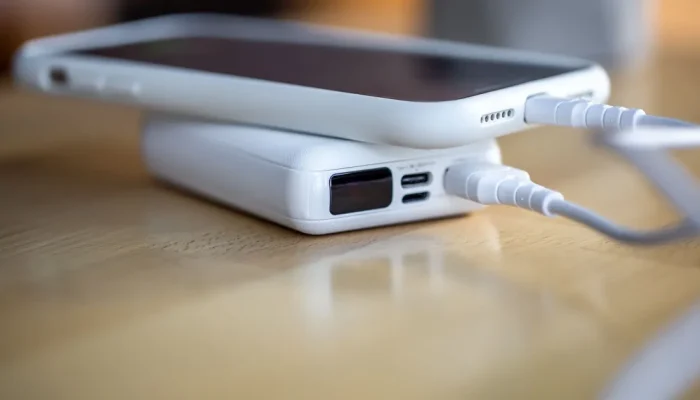 el-telefono-inteligente-se-carga-desde-un-pequeno-banco-de-energia-blanco-traves-de-un-cable-de-cerc.webp